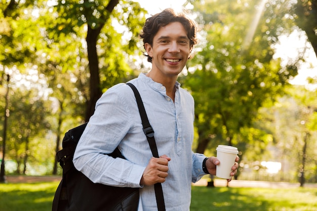 Happy young casual man drinking coffee