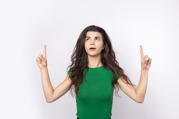 Happy young caucasian female in a shirt pointing fingers away