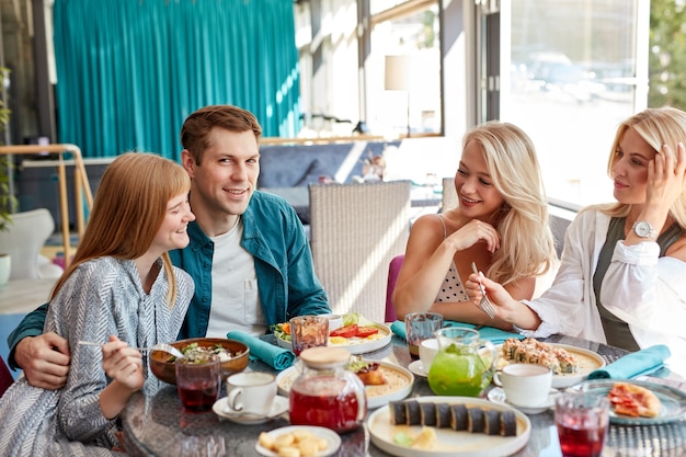 Happy young caucasian friends gathering in cafe,