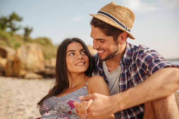 Happy young cheerful couple having fun camping at the beach