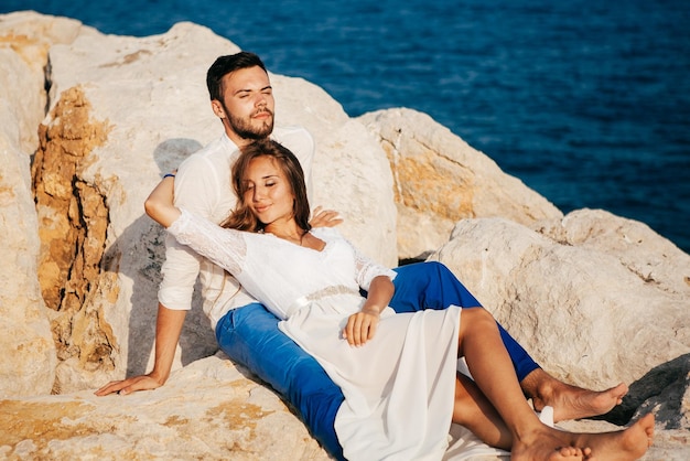 Happy young couple on the beach in love embracing and hugging smiling