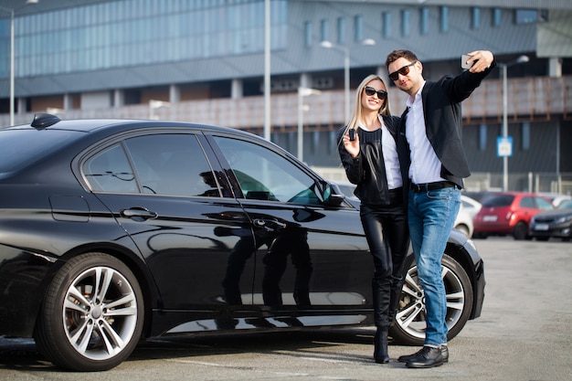 Happy young couple chooses and buying a new car for the family.