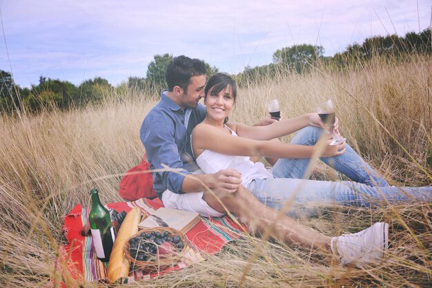 happy young couple enjoying  picnic on the countryside in the field  and have good time