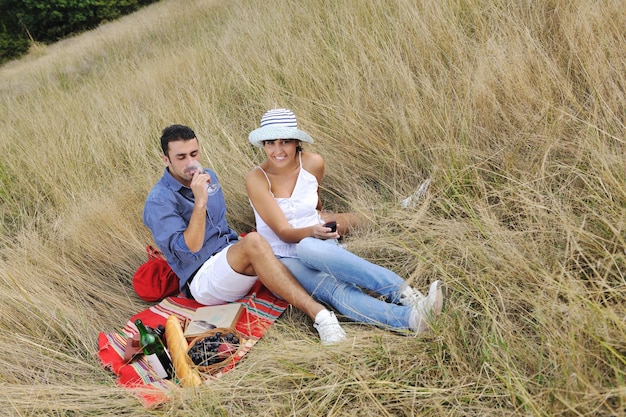 happy young couple enjoying  picnic on the countryside in the field  and have good time