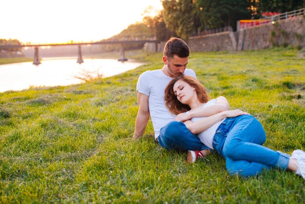 Happy young couple enjoys one another and resting by the river