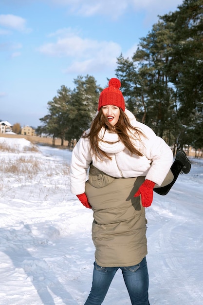 Happy young couple fooling around in winter forest Lovers walk in snowy park Vertical frame