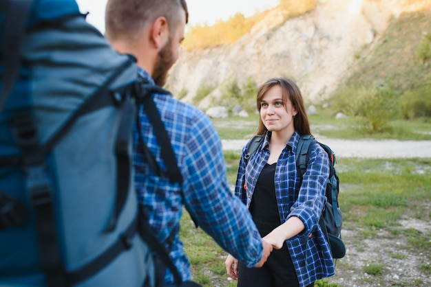 Photo happy young couple hiking in mountain