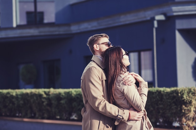 Happy young couple hugging and laughing outdoors