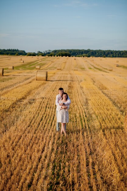 Happy young couple hugging on straw field