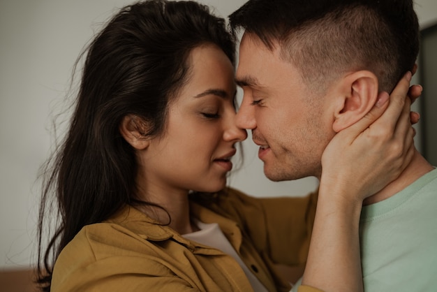 Happy young couple is kissing with passion and love, close up. Young family moving to new apartment.