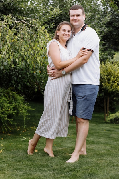 Happy young couple kissing and hugging outdoors on summer day