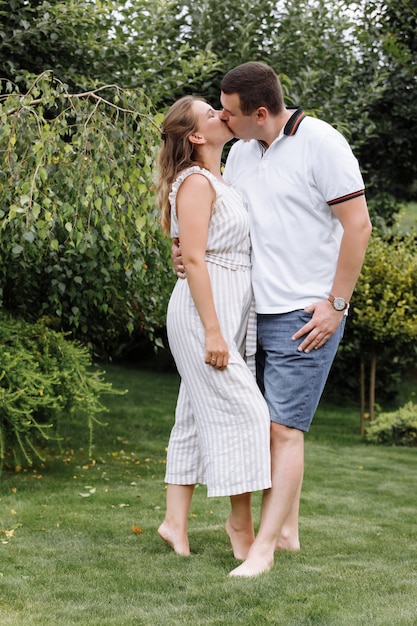 Happy young couple kissing and hugging outdoors on summer day