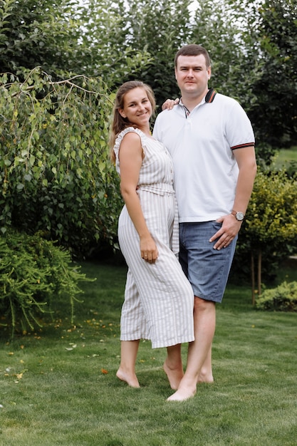 Happy young couple kissing and hugging outdoors on summer day