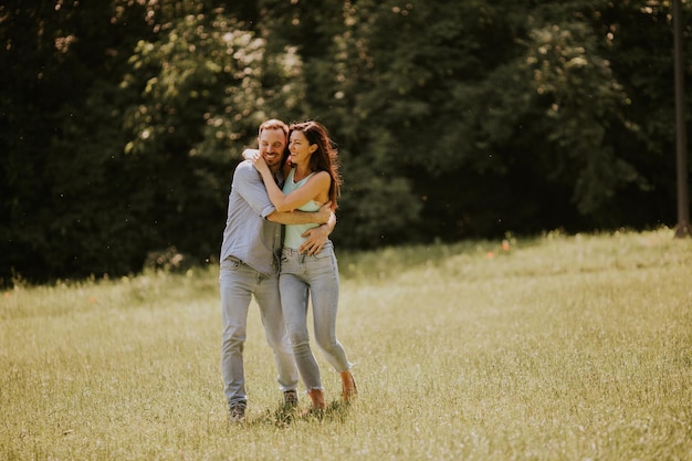 Happy young couple in love at the grass field