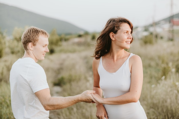 Happy young couple on nature background. Girl looking aside. Love concept