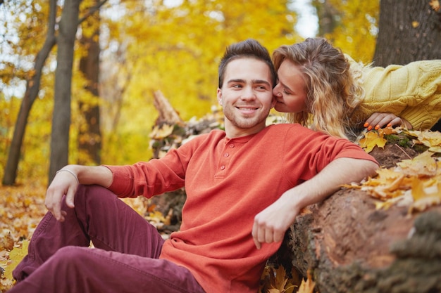 Happy young couple outdoors on a beautiful autumn day in the forest