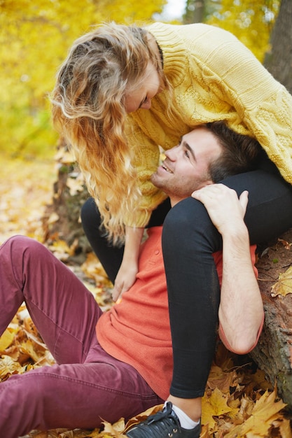 Happy young couple outdoors on a beautiful autumn day in the forest