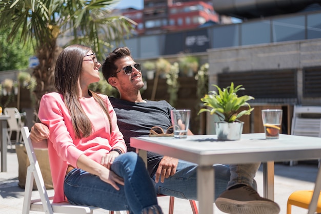 Happy young couple seating relaxed in a restaurant terrace