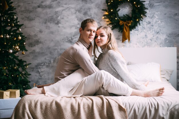 Happy young couple staying in bed at home