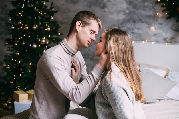 Happy young couple staying in bed at home