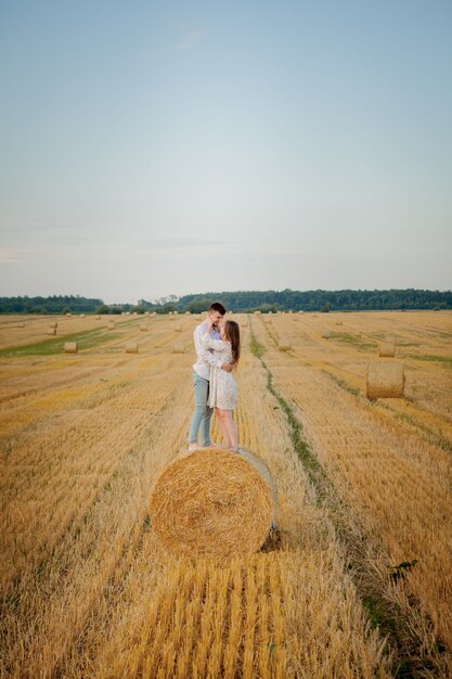 Happy young couple on straw, romantic people concept, beautiful landscape, summer season.