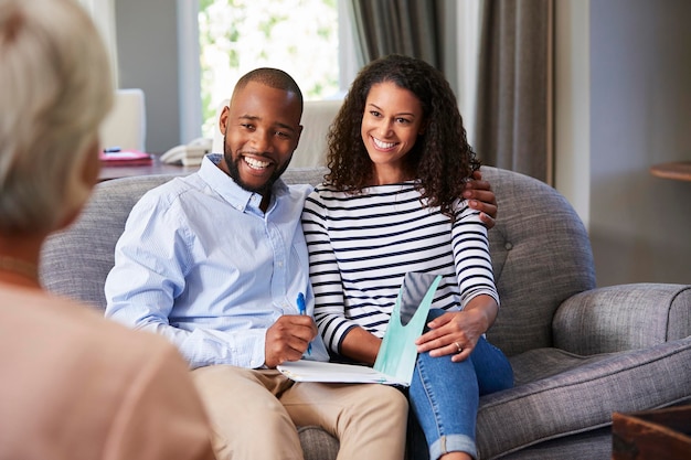 Happy young couple taking financial advice at home