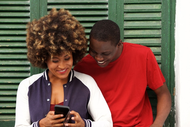 Happy young couple together with mobile phone