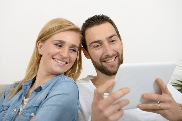 Happy young couple using digital tablet