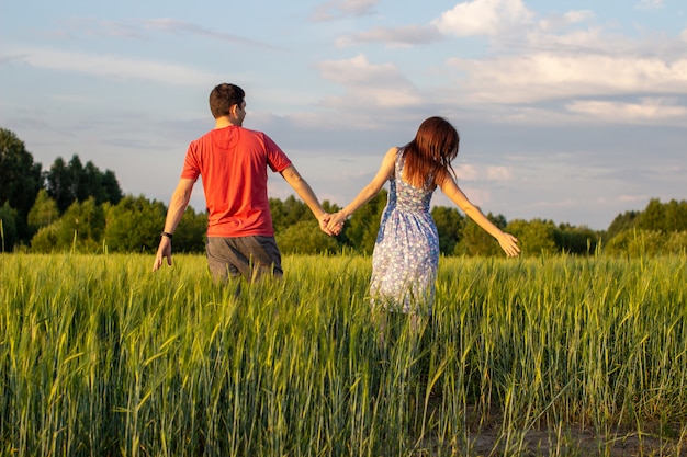 Happy young couple walking together on a field