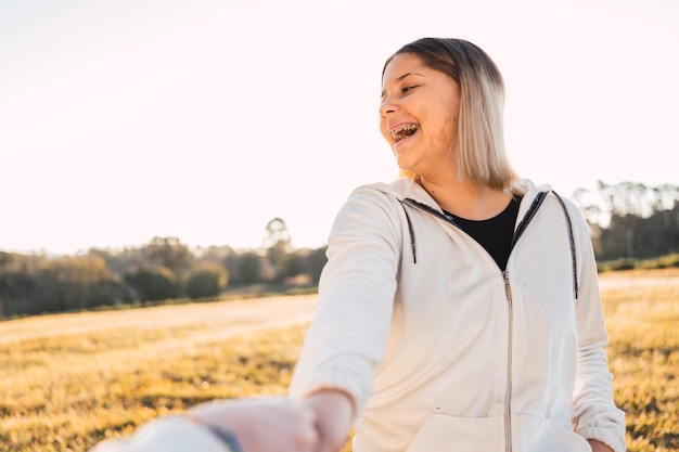 Happy young couple walking together in a park holding hands.