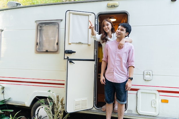 Happy young couple with a camper RV van motorhome