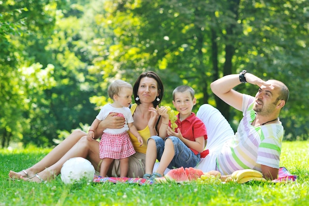 happy young couple with their children have fun at beautiful park outdoor in nature