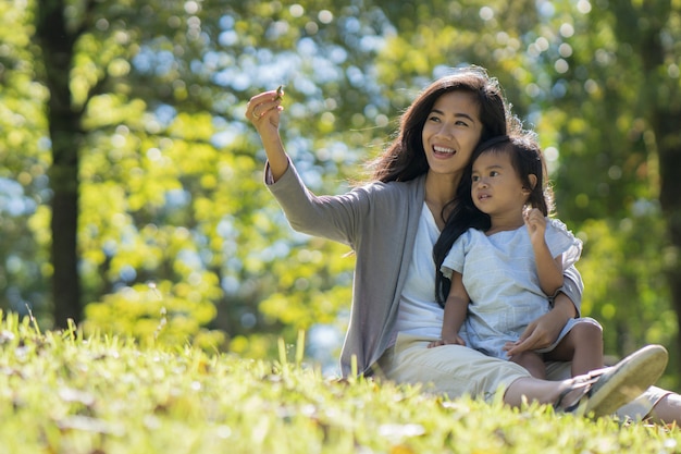 Happy young daughter with mom in the park