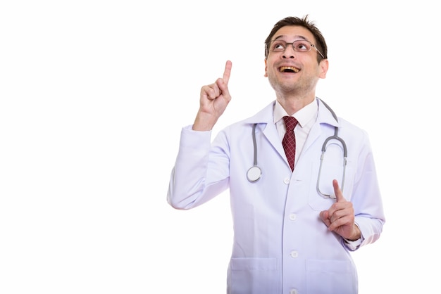 Happy young doctor smiling and wearing eyeglasses while pointing up