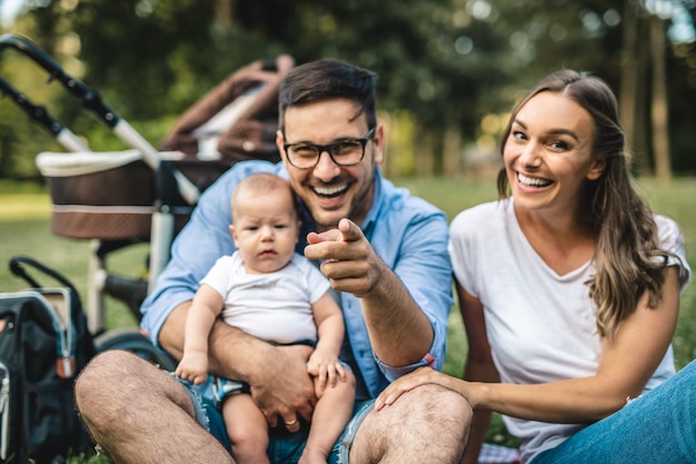 Happy young family enjoying together in park.