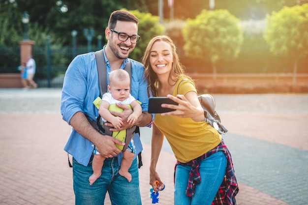 Happy young family enjoying together and taking selfie photo.