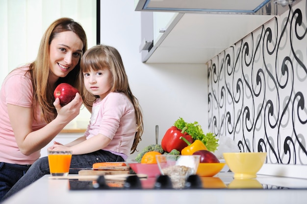 happy young family have lunch time with fresh fruits and vegetable food in bright kitchen