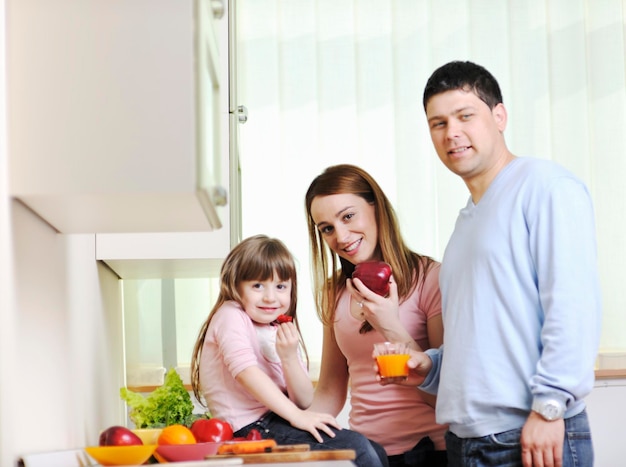 happy young family have lunch time with fresh fruits and vegetable food in bright kitchen