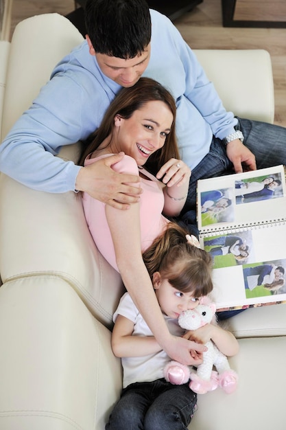 happy young family looking old pictures in photo album at home