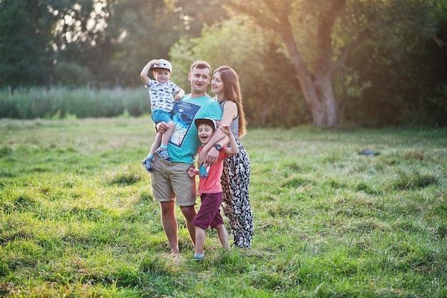 Happy young family mother father two children son on nature having fun