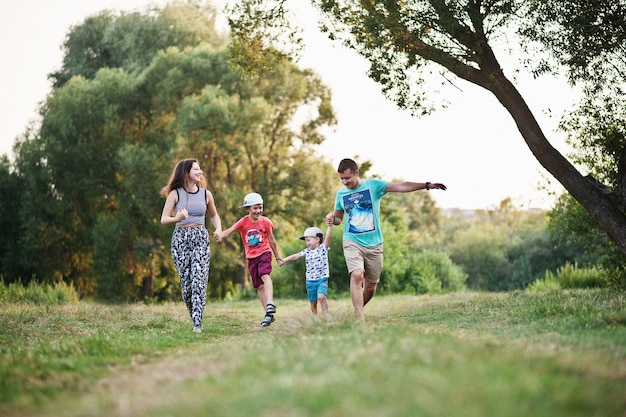 Happy young family mother father two children son on nature having fun