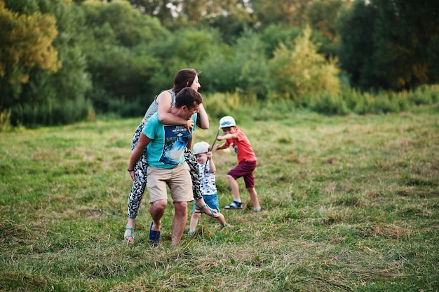 Happy young family mother father two children son on nature having fun