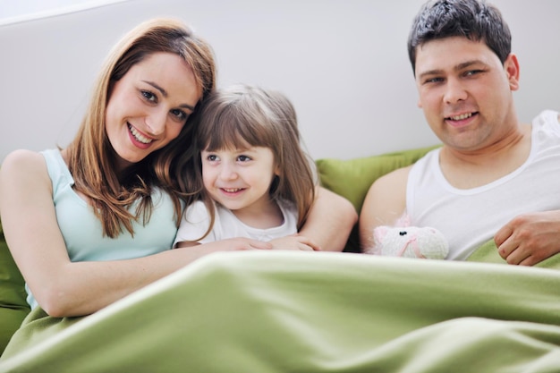 happy young family relaxing in bed