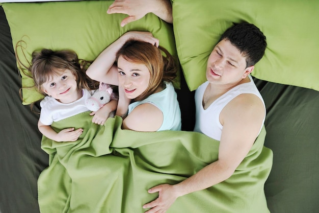 happy young family relaxing in bed