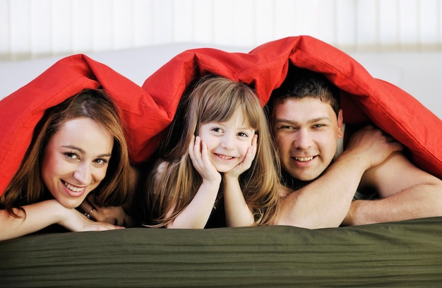 happy young family relaxing in bed