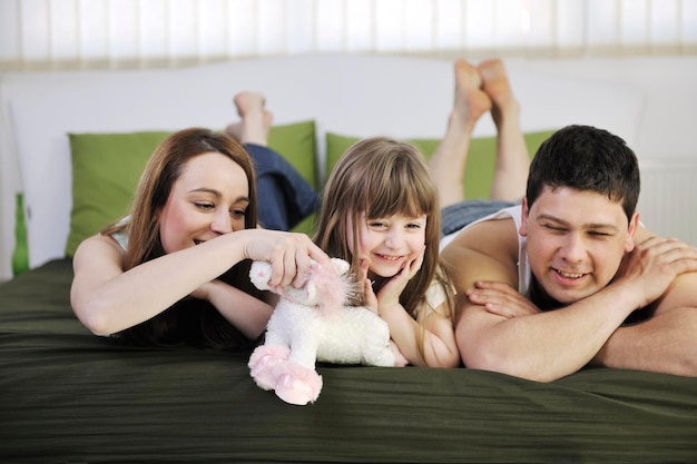 happy young family relaxing in bed