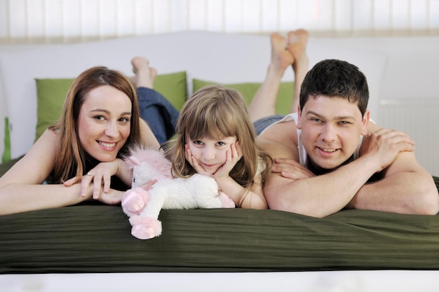 happy young family relaxing in bed