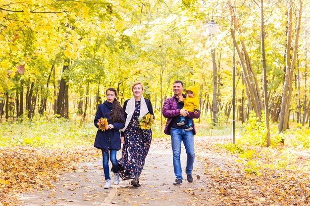 Happy young family spending time together outside in autumn nature