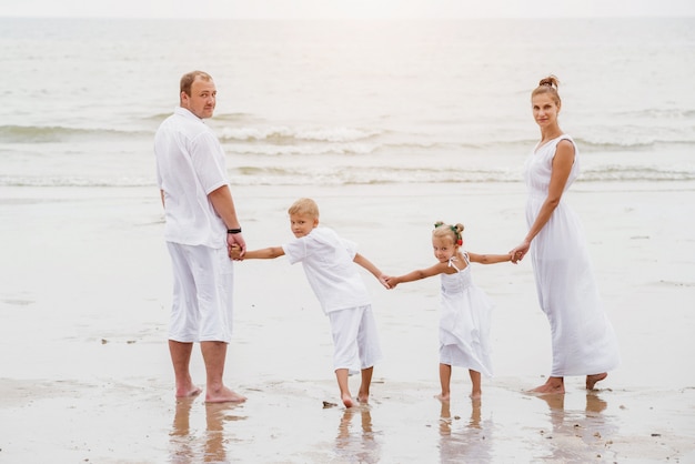 Happy young family on the sunset at the beach.