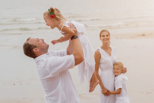 Happy young family on the sunset at the beach.